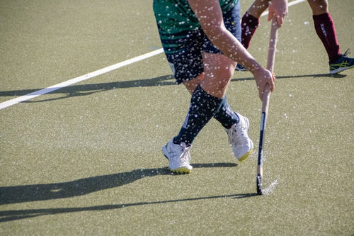 Detalle de sticks y bola sobre el césped